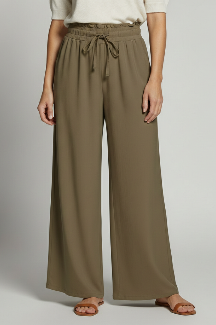 Women's palazzo trousers by THE WHITMORE FAMILY with elastic waist and side pockets, flowy and comfortable for casual wear.