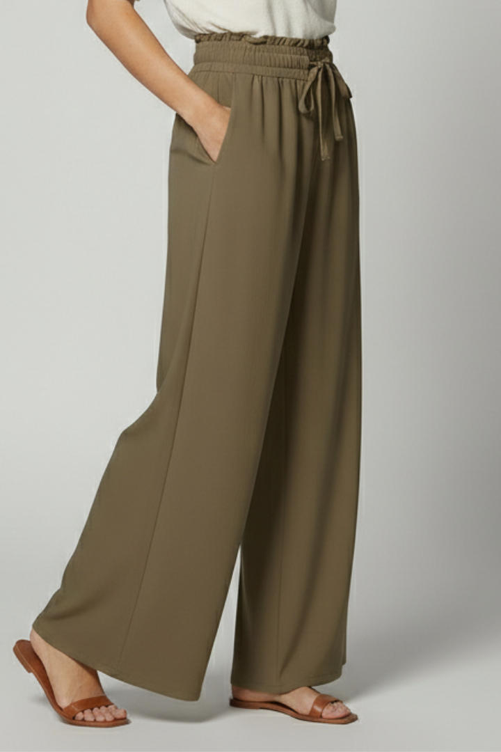 Women’s Palazzo Trousers by THE WHITMORE FAMILY featuring an elastic waist and side pockets, styled in lightweight fabric.