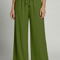 Women's Palazzo Trousers by THE WHITMORE FAMILY with elastic waist and side pockets, shown in a relaxed fit and flowy fabric.