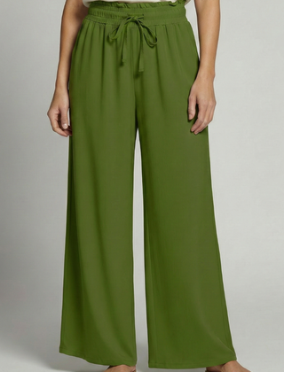 Women's Palazzo Trousers by THE WHITMORE FAMILY with elastic waist and side pockets, shown in a relaxed fit and flowy fabric.