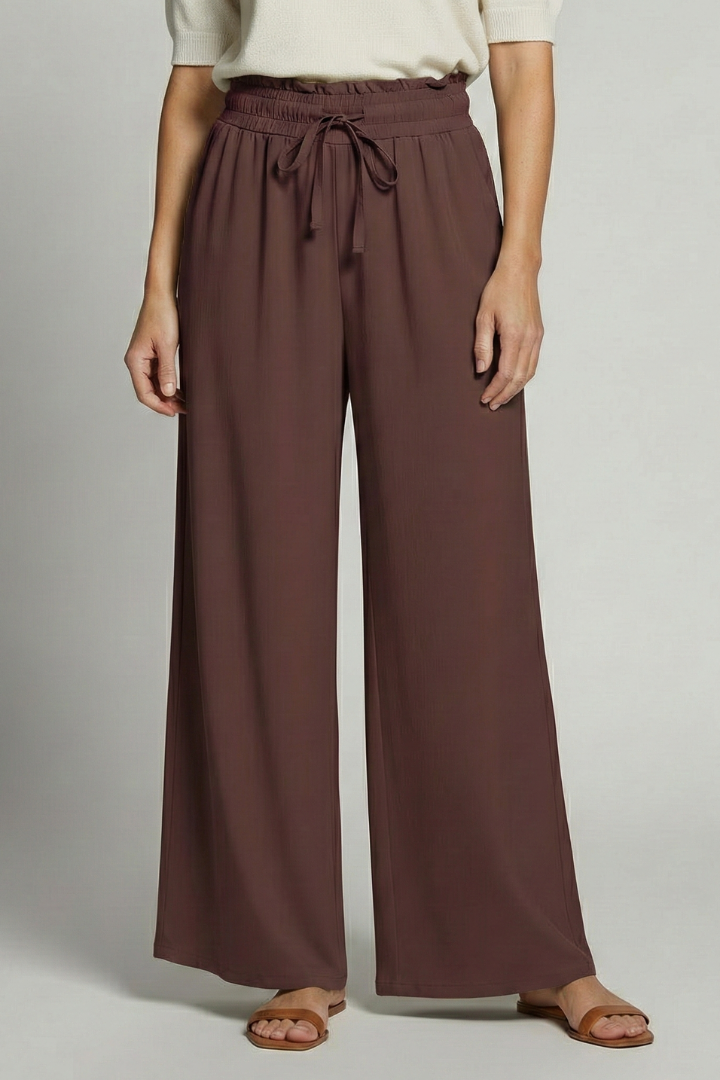 Women’s Palazzo Trousers with elastic waist and side pockets, featuring flowy fabric and a relaxed fit by THE WHITMORE FAMILY.