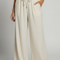 Women's Palazzo Trousers by THE WHITMORE FAMILY with elastic waist and side pockets, shown in a relaxed fit and lightweight fabric.