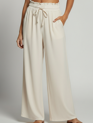 Women's Palazzo Trousers by THE WHITMORE FAMILY with elastic waist and side pockets, shown in a relaxed fit and lightweight fabric.