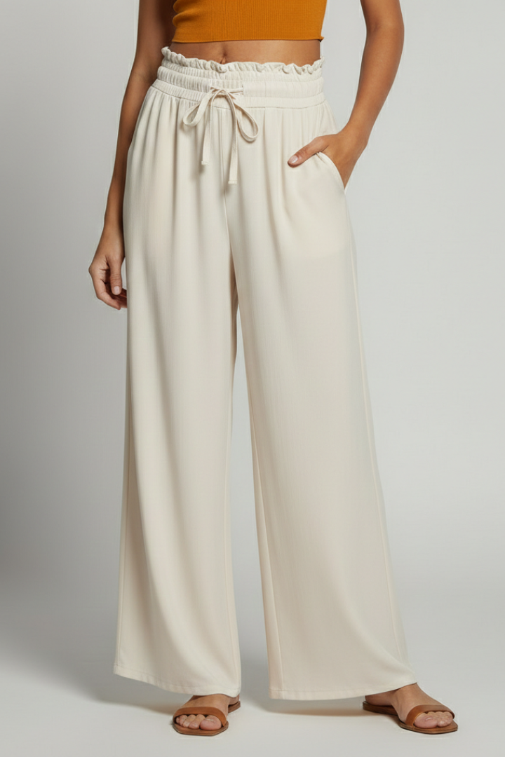 Women's Palazzo Trousers by THE WHITMORE FAMILY with elastic waist and side pockets, shown in a relaxed fit and lightweight fabric.
