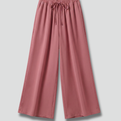 Women’s pink Palazzo Trousers by THE WHITMORE FAMILY with elastic waist and side pockets, styled casually on model.