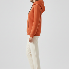 Women's hoodie pullover by THE WHITMORE FAMILY with sherpa lining and ribbed cuffs, shown on a model.