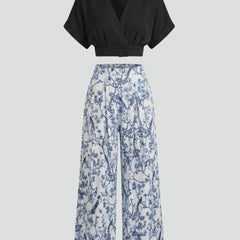 Women’s black two-piece set with V-neck top and wide-leg trousers by THE WHITMORE FAMILY, shown on a model.