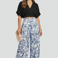 Women’s black two-piece set with V-neck top and wide-leg trousers from THE WHITMORE FAMILY, styled on a model.