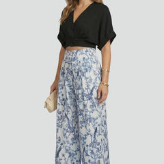 Black women’s two-piece set with V-neck top and wide-leg trousers from THE WHITMORE FAMILY, styled for a casual look.