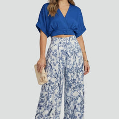 Women’s black two-piece set with V-neck top and wide-leg trousers by THE WHITMORE FAMILY, shown on a model.