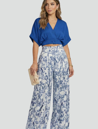 Women’s black two-piece set with V-neck top and wide-leg trousers by THE WHITMORE FAMILY, shown on a model.