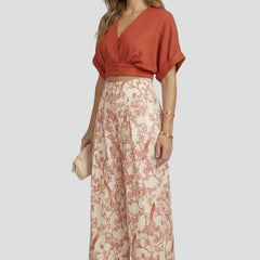 Women’s black two-piece set with V-neck top and wide-leg trousers from THE WHITMORE FAMILY, casual stylish women's outfit.