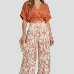 Women’s black two-piece set by THE WHITMORE FAMILY featuring a V-neck top and wide-leg trousers, styled on a model.