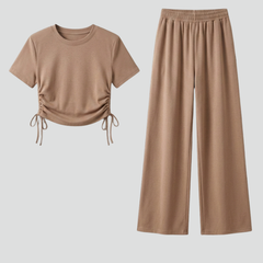 Women’s two-piece set with short sleeve top and wide-leg trousers from THE WHITMORE FAMILY, styled casually.
