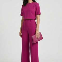 Women’s two-piece set by THE WHITMORE FAMILY featuring a short sleeve top and wide-leg trousers, styled for casual or office wear.
