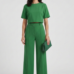 Women’s two-piece set by THE WHITMORE FAMILY featuring a short sleeve top and wide-leg trousers, styled casually.