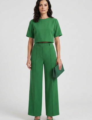 Women’s two-piece set by THE WHITMORE FAMILY featuring a short sleeve top and wide-leg trousers, styled casually.