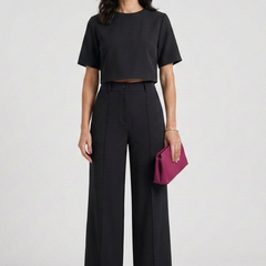 Women’s two-piece set with short sleeve top and wide-leg trousers by THE WHITMORE FAMILY, shown styled for casual wear.