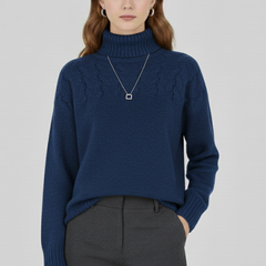 Women’s sweater with turtleneck and textured cable pattern by THE WHITMORE FAMILY, showing a cozy knit design in neutral tones.