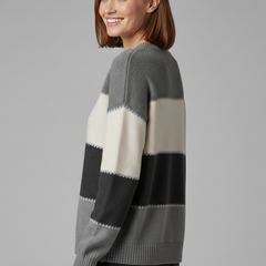 Women’s striped knit sweater from THE WHITMORE FAMILY featuring a round neckline and ribbed trim, worn by a woman.