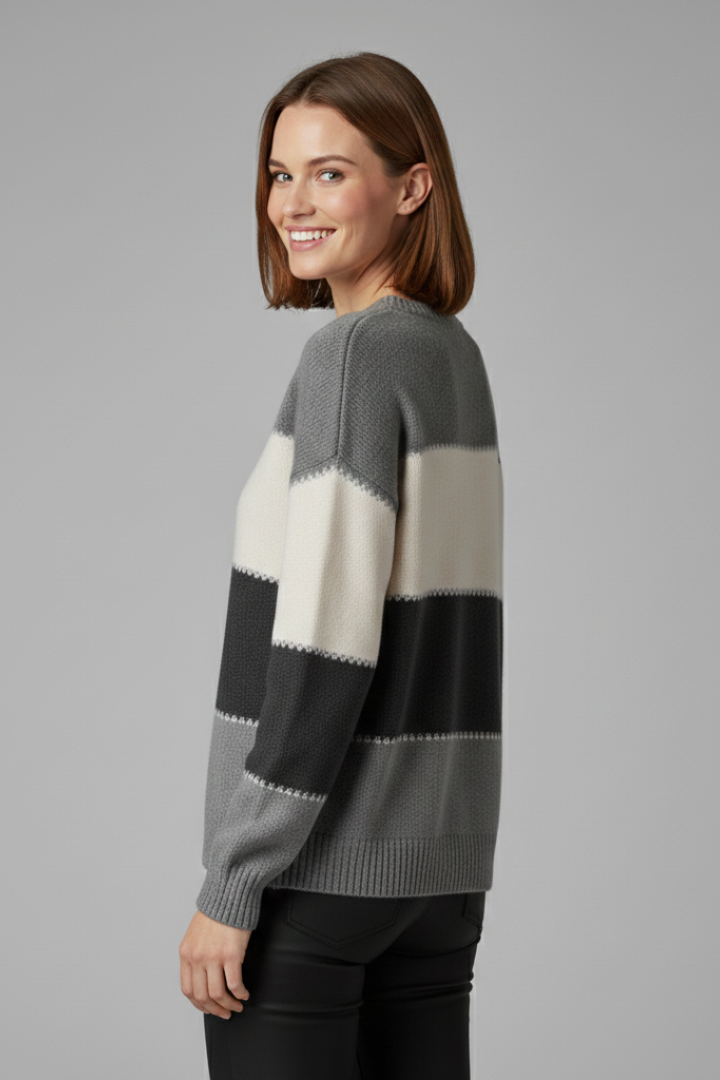Women’s striped knit sweater from THE WHITMORE FAMILY featuring a round neckline and ribbed trim, worn by a woman.