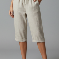 Beige women's knee-length trousers with high-waisted fit and straight legs from THE WHITMORE FAMILY, shown on a model.