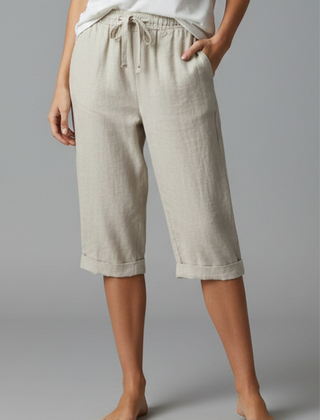 Beige women's knee-length trousers with high-waisted fit and straight legs from THE WHITMORE FAMILY, shown on a model.