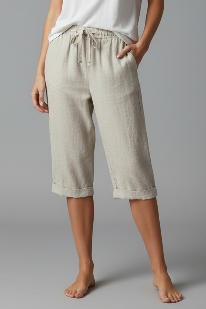 Beige women's knee-length trousers with high-waisted fit and straight legs from THE WHITMORE FAMILY, shown on a model.