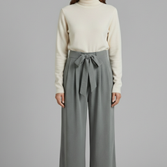 Beige women's palazzo trousers with tie waist from THE WHITMORE FAMILY, featuring a flowy, wide-leg design and comfortable fit.