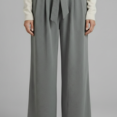 Beige women’s palazzo trousers with tie waist from THE WHITMORE FAMILY, shown lying flat on a light surface.