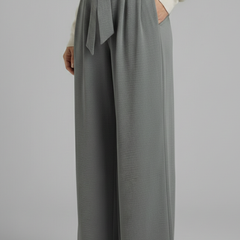 Beige women's palazzo trousers with tie waist from THE WHITMORE FAMILY, featuring a flowy, wide-leg design and comfortable fit.
