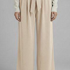 Beige women’s palazzo trousers with tie waist from THE WHITMORE FAMILY, featuring a relaxed fit and comfortable design.