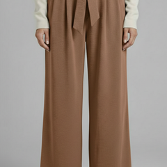 Beige women's palazzo trousers with tie waist from THE WHITMORE FAMILY, featuring a flowy fit and stylish design.