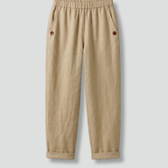Beige women’s trousers from THE WHITMORE FAMILY featuring an elastic waistband and side pockets, shown on a model.