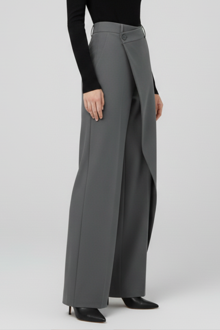 Women’s trousers by THE WHITMORE FAMILY with asymmetric front design and straight-leg cut, shown in a neutral fabric and fit.