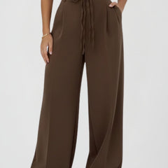 Women’s wide leg trousers with tie waist and high rise from THE WHITMORE FAMILY, showing the stylish fit and fabric texture.