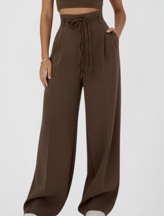 Women’s wide leg trousers with tie waist and high rise from THE WHITMORE FAMILY, showing the stylish fit and fabric texture.