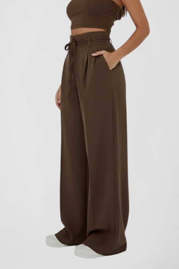 Women’s wide leg trousers with tie waist and high rise from THE WHITMORE FAMILY, showing the relaxed fit and stylish design.