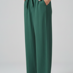 Green women’s trousers with elastic waist and tie belt by THE WHITMORE FAMILY, shown on a model.
