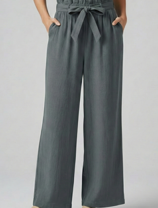Green women's trousers with elastic waist and tie belt by THE WHITMORE FAMILY, shown on a model.