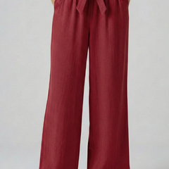 Green women's trousers with elastic waistband and tie belt by THE WHITMORE FAMILY, shown on a model.