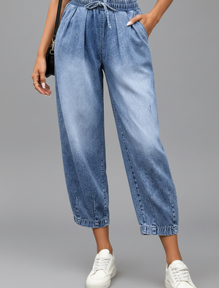 Women’s cropped trousers by THE WHITMORE FAMILY featuring a drawstring waist and pleats, shown in a stylish fit and fabric.