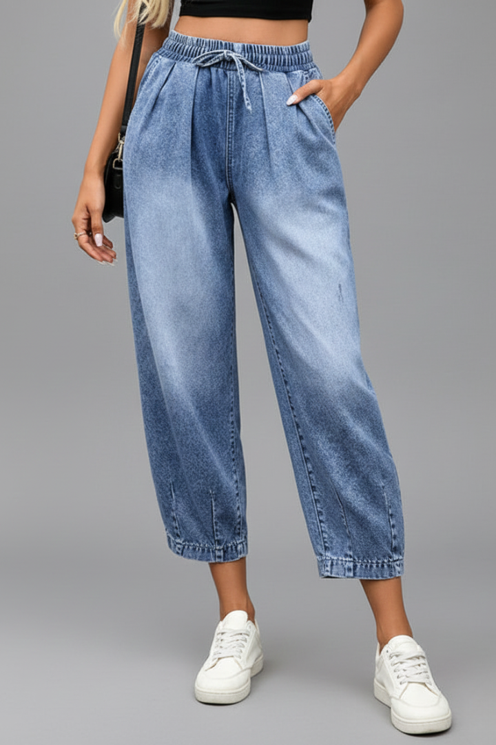 Women’s cropped trousers by THE WHITMORE FAMILY featuring a drawstring waist and pleats, shown in a stylish fit and fabric.