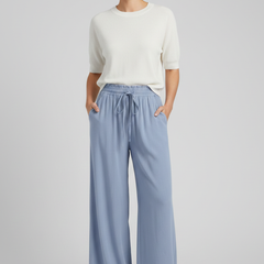 Light blue women's palazzo trousers by THE WHITMORE FAMILY with drawstring waist and side pockets, casual and comfortable fit.