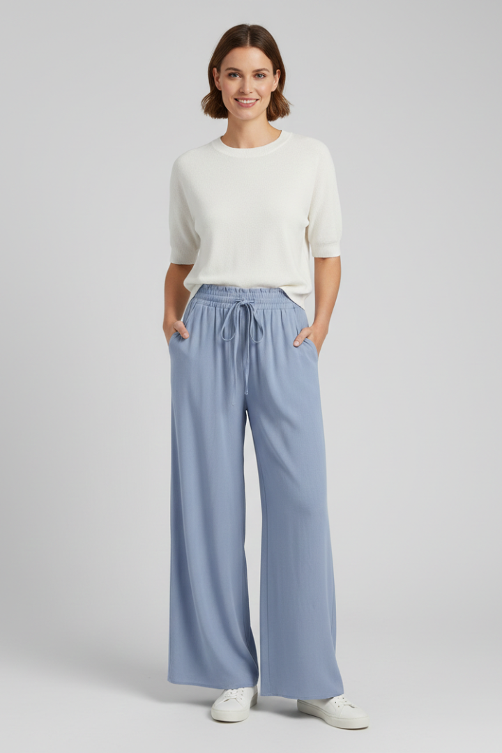 Light blue women's palazzo trousers by THE WHITMORE FAMILY with drawstring waist and side pockets, casual and comfortable fit.