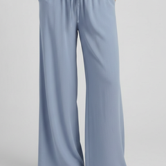 Light blue women's palazzo trousers by THE WHITMORE FAMILY with drawstring waist and side pockets.