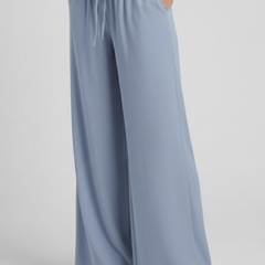 Light blue women’s palazzo trousers by THE WHITMORE FAMILY with drawstring waist and side pockets, relaxed and stylish fit.