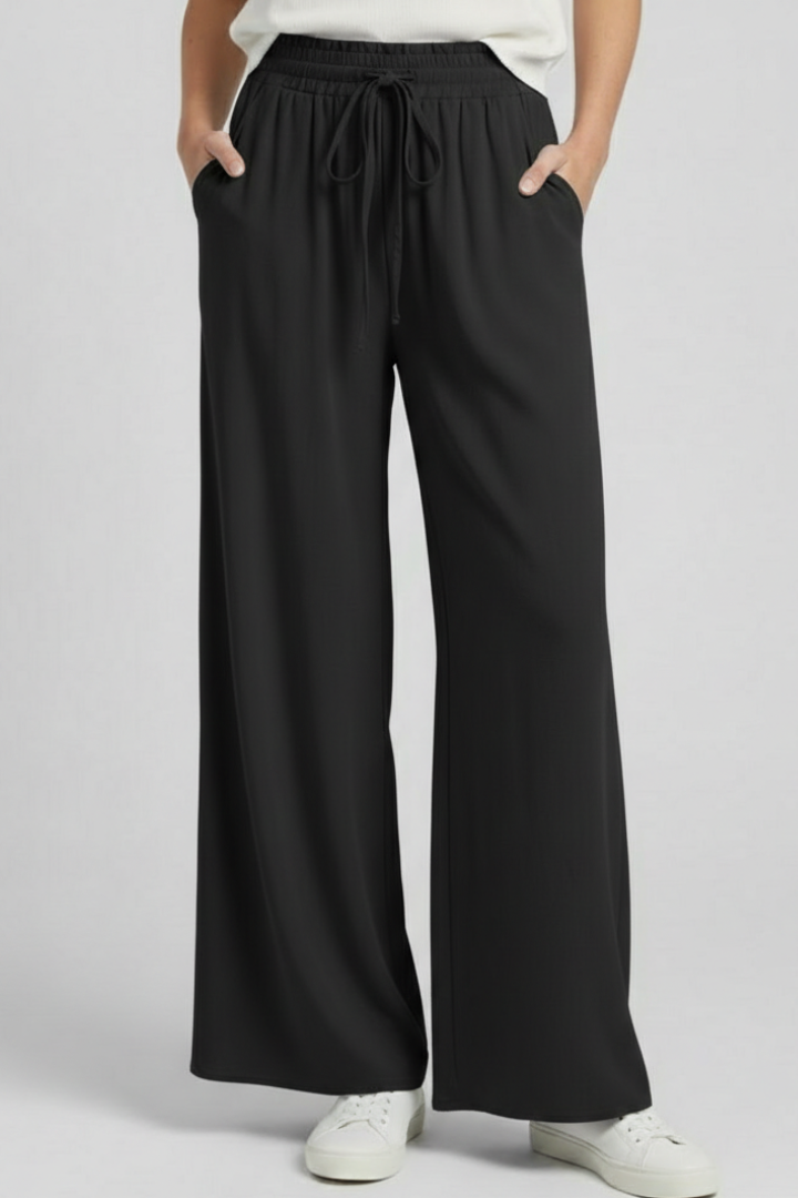 Light blue women’s palazzo trousers with drawstring waist and side pockets by THE WHITMORE FAMILY.