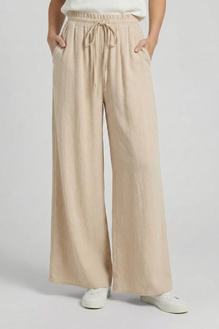 Light blue women's palazzo trousers by THE WHITMORE FAMILY with drawstring waist and side pockets, made for comfortable stylish wear.