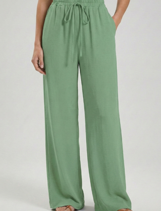 Light blue women’s palazzo trousers with drawstring waist and side pockets by THE WHITMORE FAMILY, casual and comfortable fit.